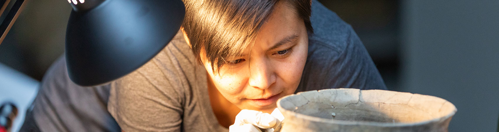 Grad student researching ancient potter in a lab